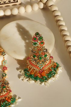 Elevate your festive attire to dreamy perfection with the Sarah - Chandelier Earrings & Maang Tikka Set, an embodiment of grandeur and allure. This exquisite earrings & maang tikka set is meticulously embellished with the splendor of multi-color stones and embellishments, adding a touch of magic to your look. The set includes a pair of stunning chandelier earrings and a maang tikka, each designed to captivate. With an approximate earring length of 3.5 inches, they are a symbol of elegance and op Festive Fusion Chandelier Earrings With Stone Work, Fusion Kundan Chandelier Earrings With Latkans, Fusion Style Kundan Chandelier Earrings With Latkans, Festive Fusion Chandelier Earrings, Festive Temple Jewelry Chandelier Dangle Earrings, Fusion Kundan Chandelier Earrings With Stone Work, Multicolor Danglers With Intricate Design For Wedding, Temple Jewelry Style Chandelier Earrings For Celebration, Celebration Temple Jewelry Chandelier Dangle Earrings