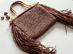 Introducing our crochet raffia bag in a rich chocolate hue, adorned with bamboo handles and finished with a trendy fringe for added charm. Fringe is all the rage right now, making this bag the perfect accessory to elevate your style. Luxury Brown Crochet Bag For Shopping, Summer Brown Crochet Bag With Tassels, Brown Crochet Bag With Tassels For Summer, Brown Fringe Shoulder Bag For Vacation, Bohemian Shoulder Bag With Bamboo Handle For Shopping, Luxury Brown Crochet Bag With Braided Handles, Brown Luxury Crochet Bag With Braided Handles, Brown Fringed Crochet Bag For Summer, Chic Brown Straw Bag With Braided Handles