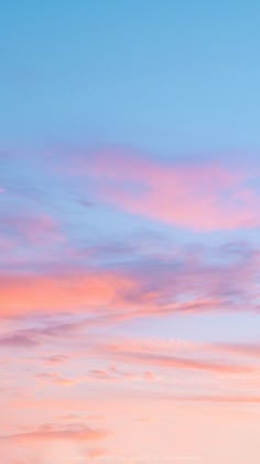 an airplane is flying in the sky with pink and blue clouds behind it at sunset