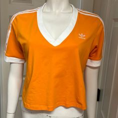 Great Cropped Length Athletic/Athleisure Shirt By Adidas! In A Vibrant Orange With White Stripes, Embroidered Logo, And Cuffed Sleeves, This Top Has Sporty Style! Size 1x (Armpit To Armpit: 20.5” Length: 19”) New With Tags! Summer Relaxed Fit Tops With Three Stripes, Adidas Sportswear Tops For Summer, Casual Relaxed Fit Tops With Three Stripes, Trendy Adidas Stretch Tops, Adidas Trendy Stretch Tops, Trendy Stretch Adidas Tops, Sportswear Tops With Three Stripes For Spring, Casual Adidas Tops For Summer, Casual Adidas Summer Tops