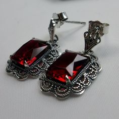 Simulated Red Ruby Solid Sterling Silver Earrings Short Festoon Design#E8z (shorter version) These Victorian reproduction estate earrings are solid sterling silver. These filigree earrings have stunning simulated red ruby gemstones. Each stunning gem is 10mm x 8mm x 5mm in dimension. The earrings are approximately 1/2" x 1" (13mm x 23mm). The unique earrings are marked 925 for solid sterling silver. These lovely earrings were refashioned from an antique Victorian cameo necklace. Quintessentially Red Sterling Silver Earrings For Wedding, Elegant Red Sterling Silver Jewelry, Red Classic Jewelry With Matching Earrings, Classic Red Jewelry With Matching Earrings, Classic Red Jewelry As A Gift, Classic Red Sterling Silver Earrings, Handmade Red Earrings For Formal Occasions, Classic Silver Ruby Earrings, Nickel-free Ruby Earrings As A Gift