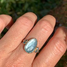 A baby blue Aquamarine is Set in 14k yellow gold with a pair of deep blue and teal sapphires and vibrant blue zircons. Emily's handmade seagrass band finishes this stunning piece. Approx stone size: 15 mm x 9mm Approx stone weight: 4.1cts Mohs Hardness: 7.5-8 This one of a kind piece is handmade to order in Emily's Hudson Valley studio. If you have questions about sizing, shipping or need help deciding please reach out to us! 14k Yellow Gold Topaz Ring With Gemstone Accents, Gold Aquamarine Gemstone Ring, Blue Topaz Ring With Rose Cut Diamonds, Fine Jewelry Blue Topaz Rings With Rose Cut Diamonds, Heirloom Rings With Rose Cut Diamonds And Blue Topaz, Heirloom Style Blue Topaz Rings With Rose Cut Diamonds, Oval Multi-stone Aquamarine Ring, Oval Aquamarine Multi-stone Rings, Yellow Gold Aquamarine Gemstone Jewelry