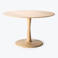 a round wooden table sitting on top of a white floor