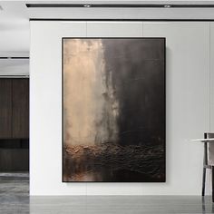 an abstract painting hangs on the wall next to a dining room table and two chairs