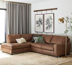 a living room with a couch, rug and two pictures on the wall above it