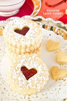 two heart shaped cookies on a plate with hearts