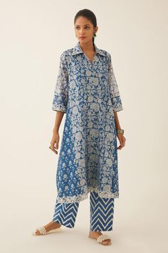 Blue A-line short kurta with bouquet hand block print and sequin, tassel, bead embroidery on collar and sleeve hem. Paired with chevron hand block printed straight pant.
Components: 2
Pattern: Hand Block Printed, Embroidery
Type Of Work: Bouquet, chevron, sequin, tassel, bead
Neckline: Shirt collar
Sleeve Type: Three quarter
Fabric: Kurta: Silk Chanderi, Pant: Cotton
Color: Blue
Other Details: 
Lined kurta
Embroidered neckline and sleeve hem
Elasticated waist at the back
Side pockets
Occasion: M Block Print Kurti Designs Latest, A Line Kurti Designs Latest Cotton, Printed Cotton Kurti Designs Latest, Block Print Kurti Designs, A Line Kurti Designs, Short Kurti Designs, Printed Kurti Designs, Collar Kurta, Simple Kurti