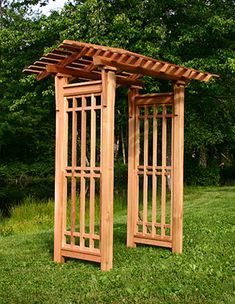 two wooden arbors sitting on top of a lush green field