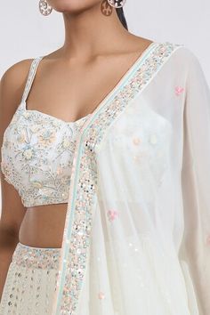 Ivory flared lehenga with all over mirror jaal rays embroidery. Paired with a sleeveless sequin-beads bloom garden embroidered blouse and a sequin clover floret motif border embroidered dupatta. - Aza Fashions White Anarkali Style Sleeveless Sharara, White Sleeveless Anarkali Sharara, White Anarkali Pre-draped Saree With Intricate Embroidery, Fitted Off White Palazzo Set With Dupatta, White Floor-length Palazzo Set With Cutdana, White Bollywood Lehenga, White Bollywood Sleeveless Lehenga, White Sleeveless Bollywood Lehenga, Festive Sleeveless White Lehenga