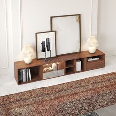 two lamps and a mirror on a shelf in front of a wall with a rug