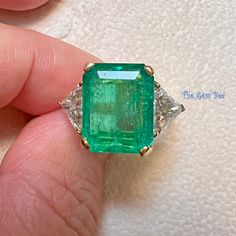 Absolutely stunning Colombian emerald mounted with 18k yellow gold  and platinum shank ! The 7.25CT emerald is from Colombia, beautiful rich green color and good clarity for its size. There are two sparkly trillion cut white diamonds adorning the center stone totaling 1.8 carat! I never understand the term "emerald garden" until I see this ring! The emerald has beautiful natural imperfections! This ring comes with one certification: Gemological Institute of America (GIA) Ring Size: 7 Total Weigh Luxury Gia Certified Emerald Gemstones, Luxury Gia-certified Trillion Cut Emerald Ring, Luxury Gia Certified Trillion Cut Emerald Ring, Formal Gia Certified Emerald Gemstones, Luxury Trillion Cut Emerald Ring For Formal Occasions, Gia Certified Trillion Cut Jewelry For Formal Occasions, Luxury Trillion-cut Emerald Ring, Gia Certified Emerald Cut Gemstones For Anniversary, Gia Certified Trillion Cut Emerald Wedding Ring