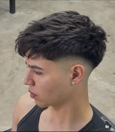 a close up of a person with a short haircut wearing a black tank top