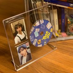 a cd case with two pictures on the front and one in the back, sitting on top of a wooden table