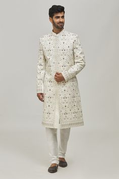 White sherwani with thread floral embroidery all-over and welt pocket in front. Comes with churidar.
Components:2
Pattern:Embroidery
Type of Work:Thread
Neckline:Mandarin Collar
Sleeve Type:Long
Fabric:Silk and Art Silk
Color:White
Other Details:
Closure: Button front
Note: 
Pocket square worn by the model is not for sale
The fabric is silk blend and not pure silk
Occasion:Groom - Aza Fashions Fitted Sherwani With Intricate Embroidery In Traditional Drape, Fitted Sherwani With Intricate Embroidery And Traditional Drape, Elegant Embroidered Sherwani Straight Kurta, Fitted Embroidered Jamawar Sherwani, Embroidered Fitted Jamawar Sherwani, Wedding Fitted Churidar With Floral Embroidery, Fitted Jamawar Sherwani With Intricate Embroidery, Long Embroidered Jamawar Bandhgala, Embroidered Long Jamawar Bandhgala