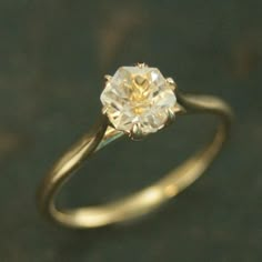 an engagement ring with a yellow diamond in the center on a black surface, close up