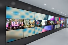 a long wall with many pictures on it in an office building or conference room,