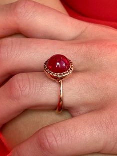 Breathtaking in its classic simplicity and timeless design, this vibrant eye catching ruby cabochon with a subtle sheen is accentuated with a pave of sparkling fancy cognac red diamonds. Alone or stacked with the rings from our collection,it is absolutely perfect. Ruby cabochon 11mm Diamonds size 1.1mm 9K solid rose gold Follow us on Instagram: https://www.instagram.com/missionewyork/ Ruby Ring Cabochon, Luxury Rose Gold Ruby Ring With Halo Setting, Formal Red Domed Rings, Red Cabochon Ruby Ring In 14k Gold, 14k Gold Red Cabochon Ruby Ring, Elegant Red Dome Ring For Anniversary, Elegant Red Dome Ring For Formal Occasions, Elegant Round Cabochon Ruby Ring, Red Domed Rings For Anniversary