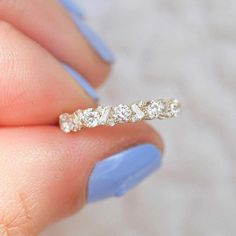 a woman's hand holding a diamond ring with three stones on the middle of it