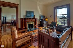 a living room filled with furniture and a fire place in front of a large window