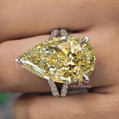 a fancy yellow diamond ring on someone's finger