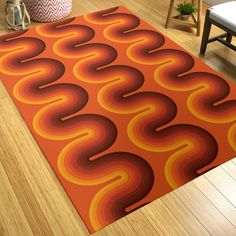 an orange and red area rug with wavy shapes on the floor next to a chair