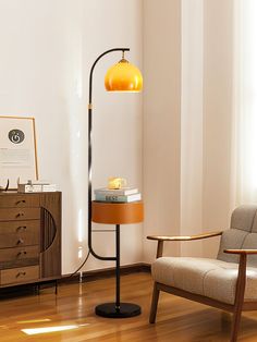 a living room with a chair, table and lamp on the floor in front of a window