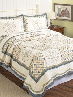 a bed with a white and blue quilt on it