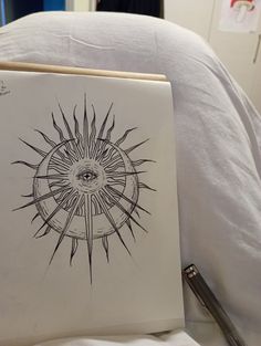 an eye drawn on top of a white sheet in front of a bed with pillows