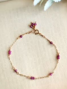 This dainty bracelet is handmade with tiny genuine ruby beads in 14K Gold Filled, Rose Gold Filled, or Sterling Silver. It is hypoallergenic and nickel-free.The delicate chain is made with a 1-2-1 stone pattern and ends with a cute cluster of 3 stones for decoration.• Gemstone size: 2-3 mm• Made with natural, genuine ruby beads📏 To find your bracelet size, measure your wrist and add 0.5 - 1 inch for room to wiggle, depending on your personal preference. For example, if your wrist is 6 inches, y Pearl Bracelet Dainty, Dainty Handmade Jewelry, Stone Bracelet Ideas, Dainty Accessories, Rainbow Moonstone Jewelry, Beads Craft Jewelry, Pearl Jewelry Design, Ruby Bracelet, Diy Jewelry Inspiration