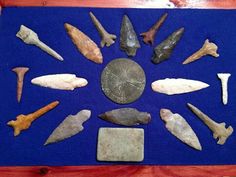 an assortment of ancient artifacts displayed on a blue mat