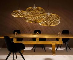 a wooden table with chairs and lights hanging from it