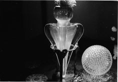 a glass vase sitting on top of a table next to a crystal ball in black and white