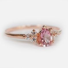 an engagement ring with a pink diamond and two white diamonds