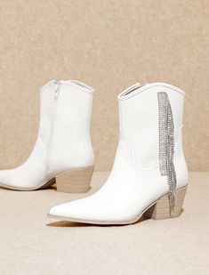 Step into a world of elegance and flair with our White Fringe Rhinestone Boots. These captivating boots seamlessly marry classic sophistication with a touch of bohemian charm, featuring delicate fringe detailing that adds a playful yet refined dimension to your ensemble. Adorned with sparkling rhinestones, these boots become a dazzling focal point, elevating your style to new heights. True to size White Rhinestone Boots For Fall, Winter Boots With Rhinestone Fringe, Glamorous White Embellished Boots, Elegant Embellished White Boots, Elegant Fringe Boots For Party, Elegant Fringe Party Boots, Rhinestone Boots, Vegan Leather Boots, White Fringe