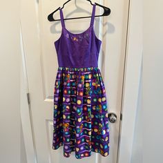 a purple dress hanging on a door with an open hanger in front of it