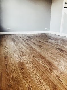 an empty room with hard wood floors and white walls