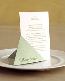 a white plate topped with a piece of paper on top of a menu card holder