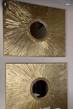 two gold mirrors on the wall above a bed