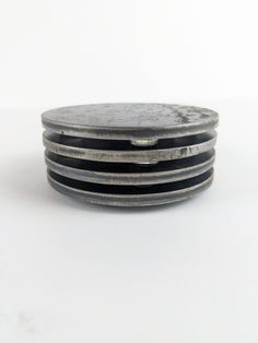 four metal plates stacked on top of each other in the shape of an oval, with black and white stripes