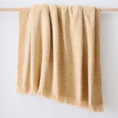 a tan blanket hanging on a white wall