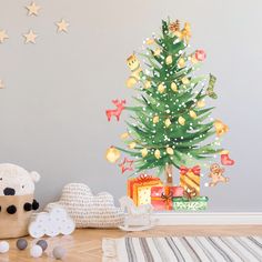 a small christmas tree sitting on top of a wooden table next to a teddy bear