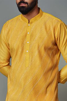 Editor's Note The yellow pintuck kurta with gota pyjama set in cotton silk is a vibrant and stylish ensemble. The yellow color adds a cheerful and sunny vibe to the outfit, while the pintuck detailing on the kurta adds texture and visual interest. Whether for festive occasions or special events, this yellow pintuck kurta set with gota pyjama is sure to make a fashionable statement and leave a lasting impression. Fabric: Cotton silk Color: Yellow Components: Kurta and pants Occasion: Festive Note Yellow Chanderi Sherwani Straight Kurta, Yellow Chanderi Sherwani With Resham Embroidery, Yellow Sherwani With Resham Embroidery In Chanderi, Yellow Bollywood Kurta With Cutdana, Yellow Bollywood Style Kurta With Cutdana, Bollywood Style Yellow Kurta With Cutdana, Yellow Bollywood-style Kurta With Cutdana, Yellow Chanderi Kurta With Cutdana, Eid Straight Kurta With Pintucks