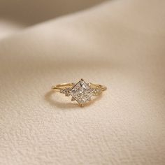 a diamond ring sitting on top of a white cloth