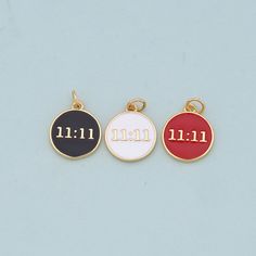 three different colored charms with the word omen written in gold, silver and red