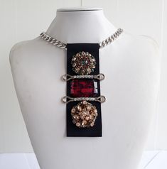 Each piece of our statement necklaces is handmade and one of a kind made in Italy. Our creations is made of high quality materials such as crystals and rhinestones. Each embroidered material is carefully hand sewn. Very glamorous and stylish. Perfect gift to someone you like. Materials Jeweled  elements and Marbled Red stones in different shape and dimension.  Application on black gross grain ribbon with gross grain ribbon backing. Aluminium chain with lobster closure. Measurements Weight approximate 150 grams. Chain lenght 45 cm - 17,71 in Jewel Tie lenght 14 cm - 5,51 in Feel free to contact us if you have any question. Thank you so much for looking at our shop and our articles each of them, single piece. Crystal Chain Necklaces For Evening, Crystal Necklaces With Chain For Evening, Jeweled Pendant Rhinestone Necklace, Evening Crystal Chain Necklaces, Jeweled Crystal Rhinestone Pendant Necklace, Crystal Rhinestone Jeweled Pendant Necklace, Costume Jewelry Rhinestone Pendant Necklace For Party, Party Crystal Pendant Necklace With Rhinestones, Luxury Crystal Embellished Metal Necklaces