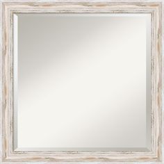 a white framed mirror sitting on top of a wall