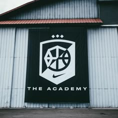 a large sign on the side of a building that says the academy with a basketball in it