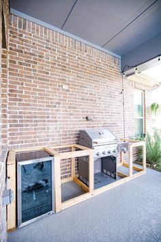 an outdoor bbq grill built into the side of a brick wall