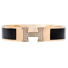 Discover the epitome of elegance with the Hermès 18K Yellow Gold Clic Clac H Diamond Black Enamel Bracelet. This iconic accessory features the signature "H" clasp, adorned with sparkling diamonds totaling 0.50 carats, adding a touch of brilliance to its timeless design. The sleek black enamel contrasts beautifully with the luxurious 18K yellow gold, creating a sophisticated and modern aesthetic. Perfectly suited for wrist sizes ranging from 5.75 to 6 inches, this bracelet offers a comfortable an Luxury Black Enamel Bracelets For Formal Occasion, Luxury Polished Diamond Bangle Bracelet, Luxury Polished Diamond Bracelet, Luxury Jubilee Bracelet Bangle For Formal Occasions, Luxury Formal Jubilee Bangle, Luxury Polished Bracelets For Evening, Luxury Polished Finish Bracelets For Evening, Luxury Diamond Bracelet For Formal Occasions, Luxury Diamond Bracelet For Formal Events