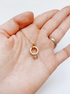 This very elegant engagement ring necklace is perfect for that special occasion. Simple and understated.  It looks great on its own or layered with other necklaces, and is the perfect everyday accessory. Item Details: Pendant: H: 10 mm L: 11 mm W: 1 mm Necklace clasp: lobster clasp. Materials: Pendant: 24k gold plated Chain: 14k gold plated, 17.5 inches or 19 inches Care Instructions: My jewelry carries powerful and positive vibrations.  Give it the care it deserves by avoiding contact with clea Minimalist Solitaire Necklace With Delicate Chain, Dainty Round Pendant Charm Necklace For Anniversary, Dainty Charm Necklaces With Round Pendant For Anniversary, Dainty Charm Necklace With Round Pendant For Anniversary, Minimalist 14k Gold Wedding Birthstone Necklace, Minimalist 14k Gold Birthstone Necklace For Wedding, Dainty Solitaire Necklace With Clavicle Chain For Anniversary, Minimalist Yellow Gold Birthstone Necklace For Wedding, Minimalist Solitaire Necklace For Wedding